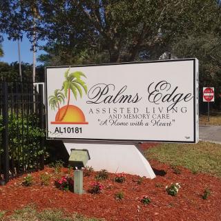 Entrance sign for Palms Edge Assisted Living Facility surrounded by landscaped area.