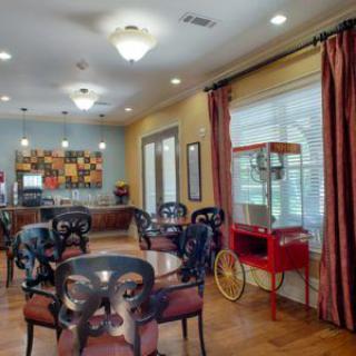 An indoor dining area featuring a popcorn machine, tables, and chairs.