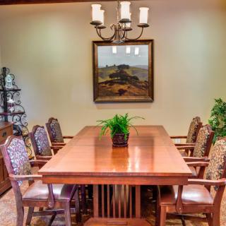 A well-furnished dining room with a wooden table, decorative chairs, and a chandelier.