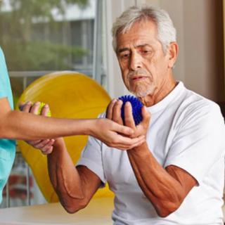 A senior man engaging in physical therapy with a caregiver assisting.