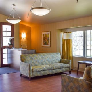 A cozy living room with a sofa, table, and large windows.