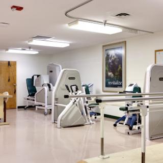 A well-equipped physical therapy room featuring various exercise machines and rehabilitation tools.