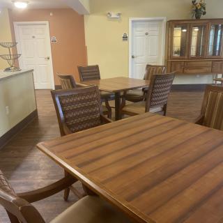 A communal dining area with wooden tables and chairs, showcasing a cozy and inviting atmosphere.