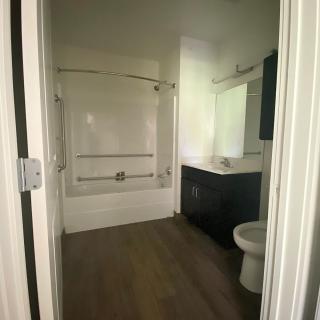 A modern bathroom with a combined shower and bathtub, sink, and toilet.