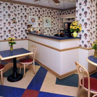 A cozy cafe interior with decorative wallpaper, tables, and chairs.