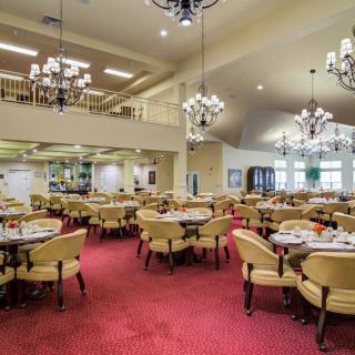 Spacious dining area with elegant chandeliers and neatly arranged tables.