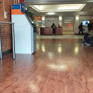 A view of a hospital waiting area with a reception desk in the background.