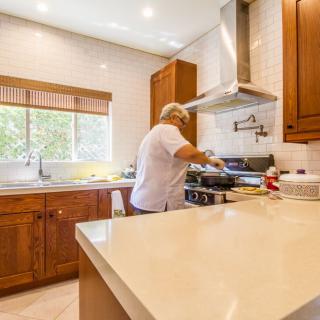A person cooking in a modern kitchen with wooden cabinets.