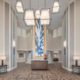 A modern hotel lobby with a striking chandelier and colorful artwork.