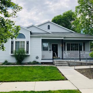 A charming suburban house with a well-maintained lawn and a covered porch.