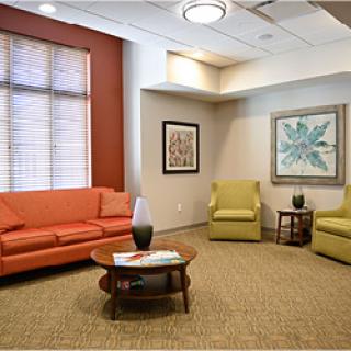 A cozy waiting room featuring colorful furniture and warm natural light.