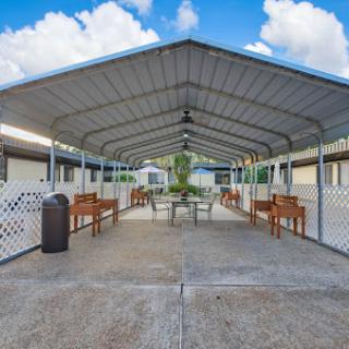 A spacious outdoor pavilion with seating and a clear blue sky.