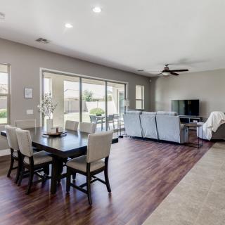 A modern open-concept living and dining area with hardwood floors and neutral color tones.