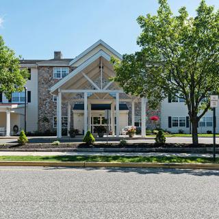 A front view of a building with a prominent entrance and surrounding trees.