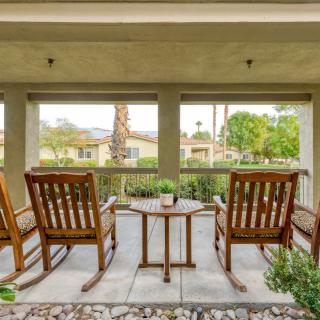 A peaceful patio with wooden rocking chairs overlooking a scenic view.