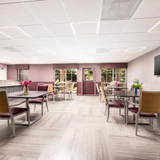 A bright and inviting dining area featuring tables, chairs, and floral arrangements.