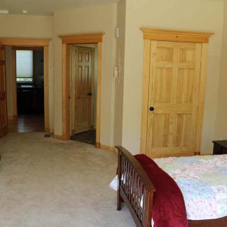 A cozy bedroom with wooden doors and a bed with a quilt.