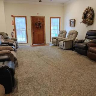 A spacious living room featuring multiple recliners with a warm and inviting atmosphere.