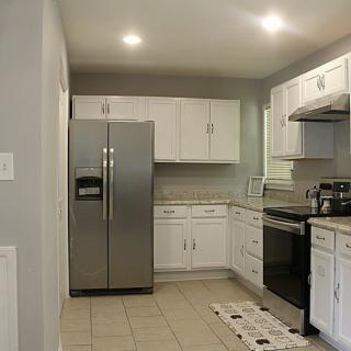 A modern kitchen featuring stainless steel appliances and white cabinetry.