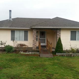 A single-story house with a chimney and a small front yard.