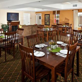 A cozy dining room with neatly arranged tables and chairs, ready for guests.