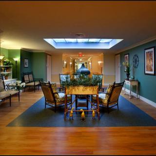 A modern dining room featuring a central table with chairs, skylight, and stylish decor.