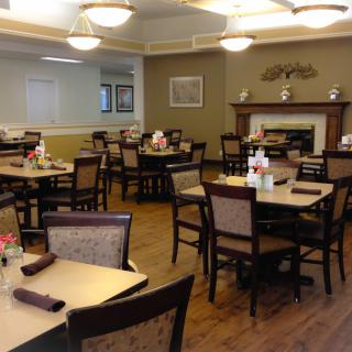An empty dining room with neatly arranged tables and chairs, featuring a cozy atmosphere.