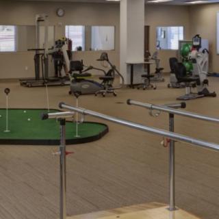 A rehabilitation facility equipped with gym equipment and a putting green.