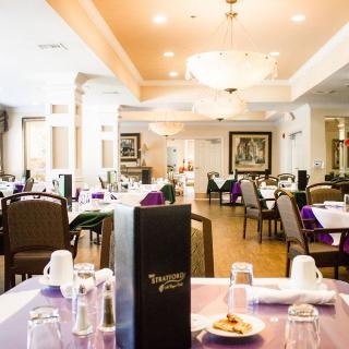 An elegant restaurant dining area with neatly arranged tables and chandeliers.