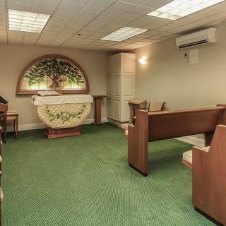 A small chapel interior with wooden pews and a decorative altar.