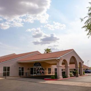 A building with an arched entrance under a partly cloudy sky.