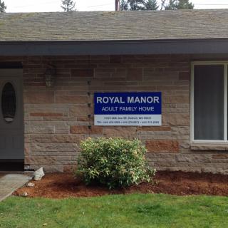 Exterior view of a residential building with a sign for Royal Manor Adult Family Home.