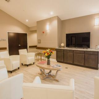 A modern waiting room featuring comfortable seating and a television.