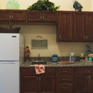 A cozy kitchen with wooden cabinets, a white refrigerator, and decorative elements.