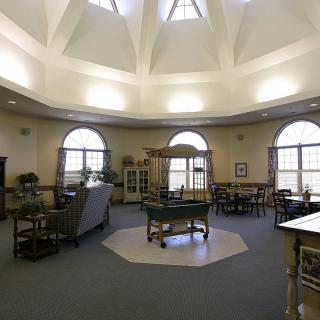 A spacious room with a dome ceiling, large windows, and various furniture pieces.