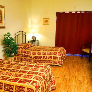 A cozy hotel room with two single beds, warm lighting, and decorative elements.