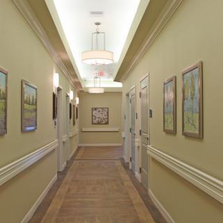A well-lit hallway adorned with paintings on either side.