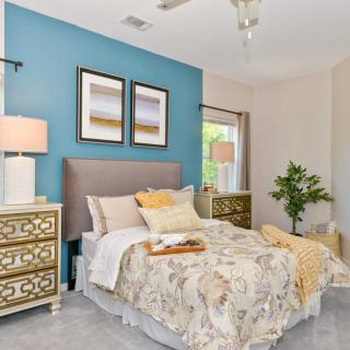 A modern bedroom with colorful walls, decorative artwork, and stylish furnishings.