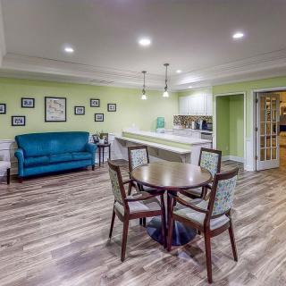 A cozy living area with a round table and chairs, adjacent to a kitchen space.