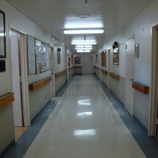 A clean and well-lit hospital corridor with multiple doors on either side.