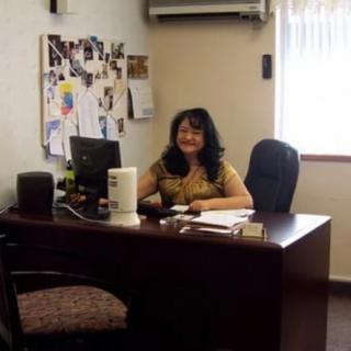 A woman sitting at a desk in an office environment.