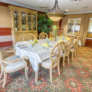 An elegantly decorated dining room with a set table and chandelier.