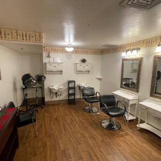 A well-equipped beauty salon with styling chairs, mirrors, and hair care tools.