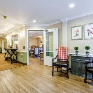 A cozy hallway with wooden flooring, decorated with artwork and comfortable seating.
