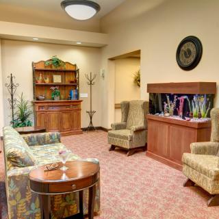 A cozy living room with comfortable seating, a bookshelf, and an aquarium.