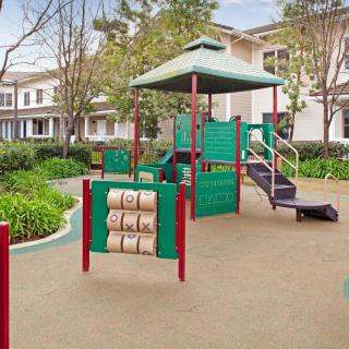 A colorful playground with various play structures in a residential neighborhood.