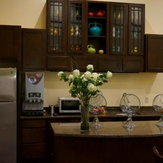 A modern kitchen with wooden cabinets, a countertop decorated with white flowers, and various appliances.