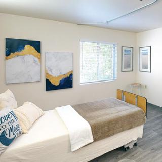 A neatly organized bedroom featuring modern artwork and a cozy atmosphere.