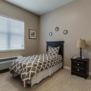 A cozy bedroom with a single bed and neutral decor.