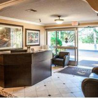A cozy lobby area with a reception desk, seating, and artwork on the walls.